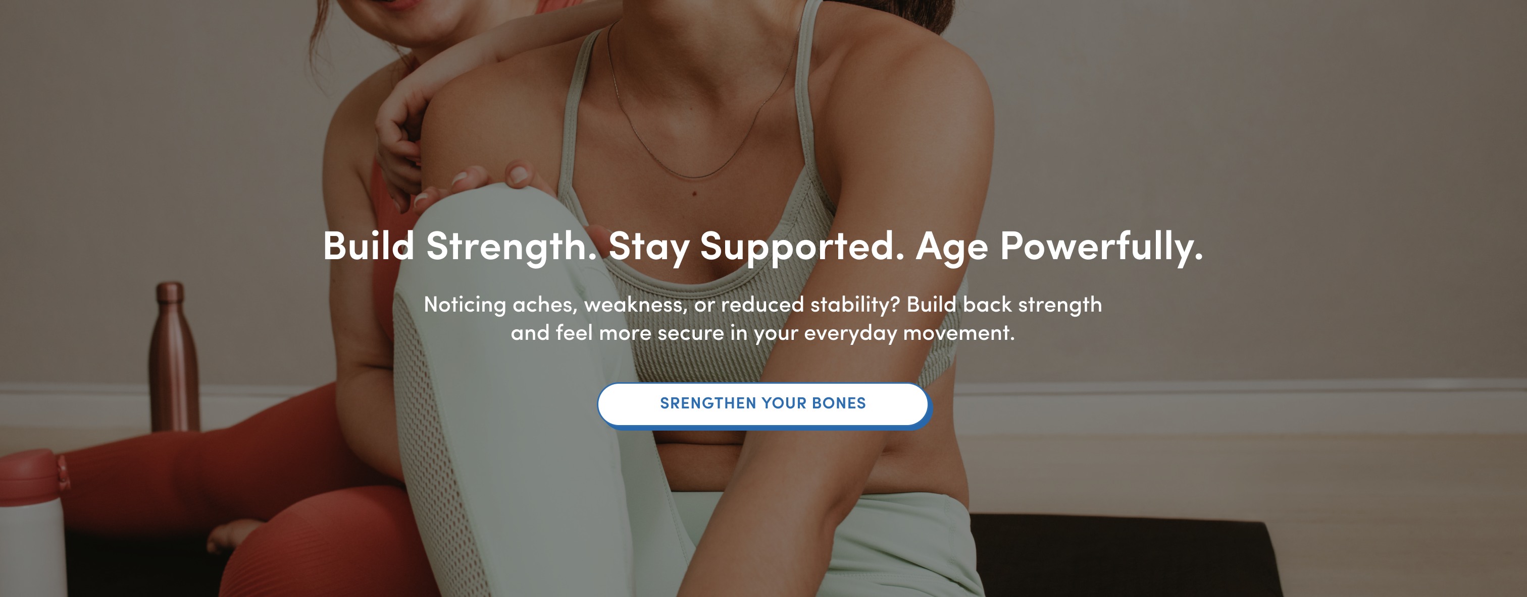 Two women in athletic wear sit on yoga mats indoors. Text over the image reads, Build Strength. Stay Supported. Age Powerfully. with a button below labeled Strengthen Your Bones.