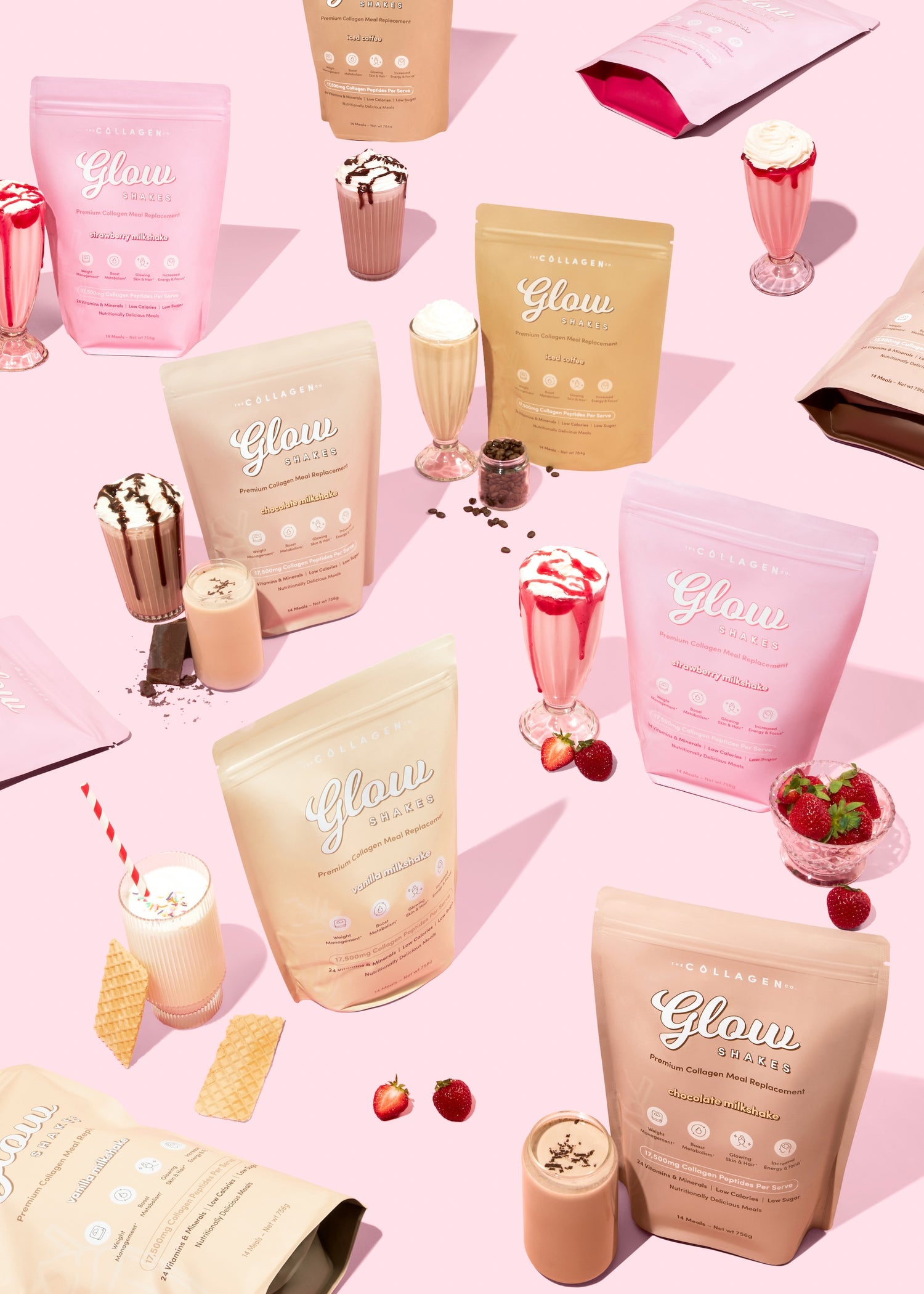 Collagen supplement bags with various flavors, surrounded by milkshake glasses, wafers, and strawberries on a pink background.