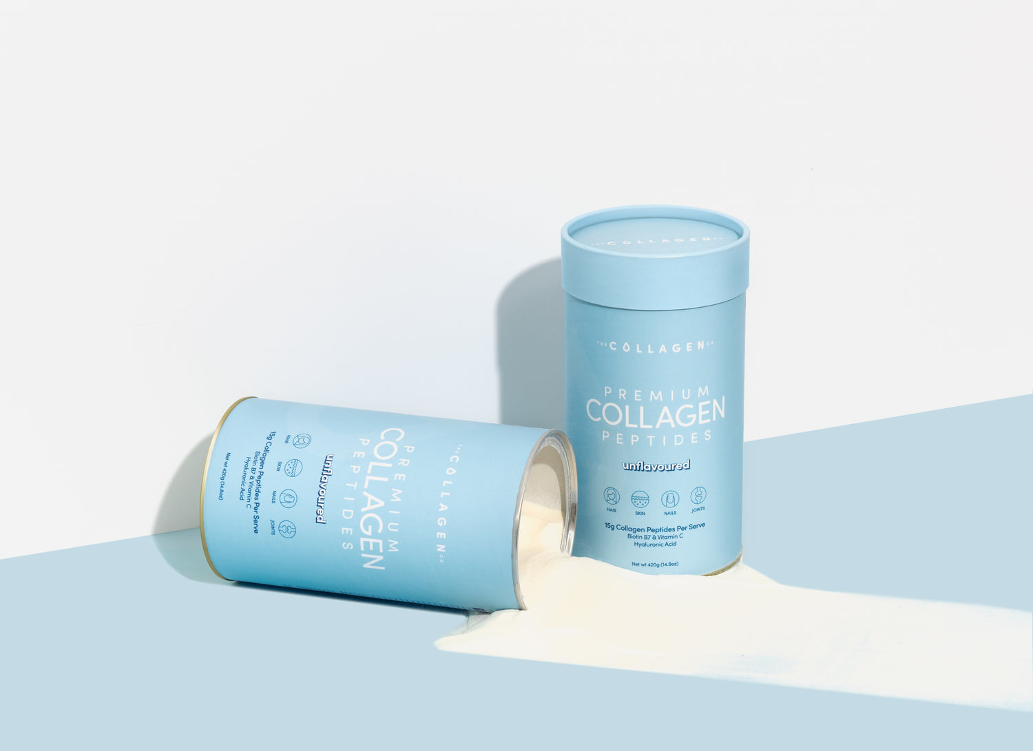 Two light blue containers of premium collagen peptides; one standing, one lying with powder spilling out. Clean, minimalist design on a white background.