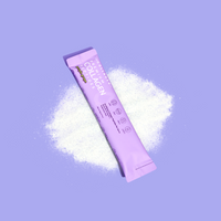 Purple collagen sachet packet on purple background with white powder splash effect