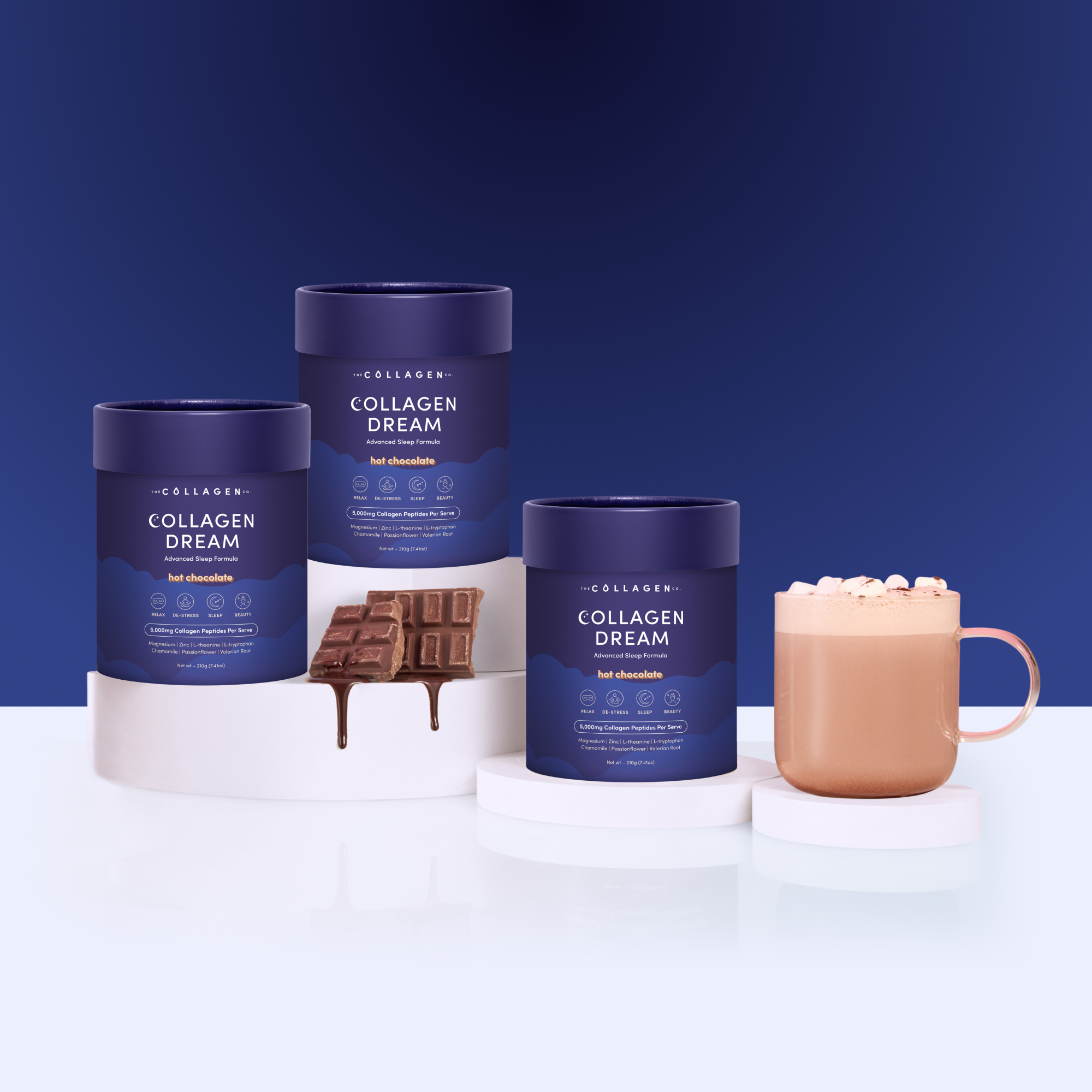Three blue containers of the Custom Advanced Sleep Trio Bundle are displayed on white platforms, alongside a chocolate bar and a mug of hot chocolate with marshmallows—all set against a blue background, perfect for supporting skin health.