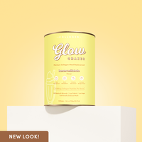 A yellow canister of Glow Shakes banana milkshake collagen meal replacement placed on a white pedestal against a pale yellow background. Text on the packaging highlights benefits like weight management, glowing skin, and metabolism boost.