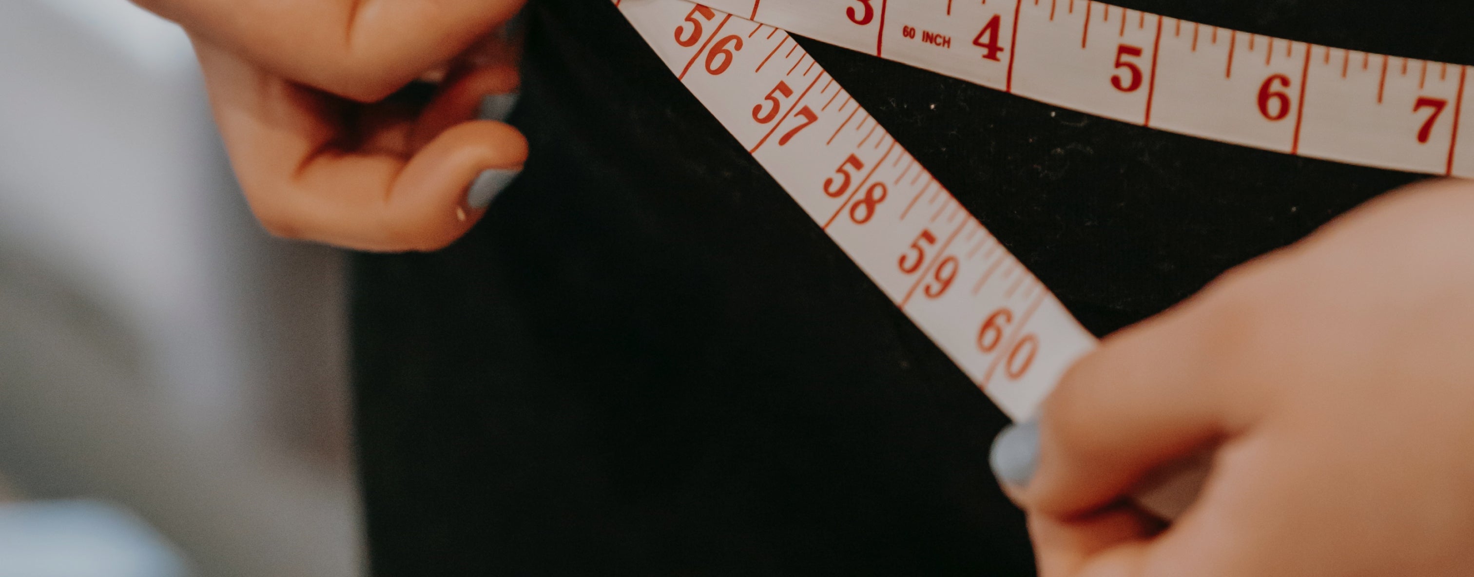Person measuring waist with a tape measure, indicating focus on fitness, health, and body transformation, linked to beauty supplements.