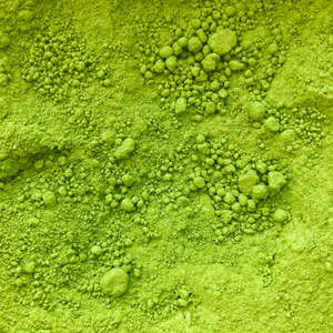 Close-up of green powdered collagen supplement forming uneven clusters and textures, highlighting natural beauty and skincare benefits.