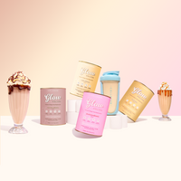 A group of Glow Shake cans in vanilla, strawberry, iced coffee and chocolate sit beside a filled Glow shaker.