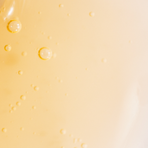 Close-up of a golden liquid with air bubbles, resembling a beauty or collagen supplement, emphasizing hydration and skincare.