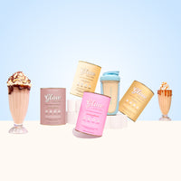 The Collagen Co USA Glow Shake Starter Kit, featuring five colorful collagen powder cans and a blue protein shaker, is displayed with two milkshakes and whipped cream on a white surface against a light blue background.