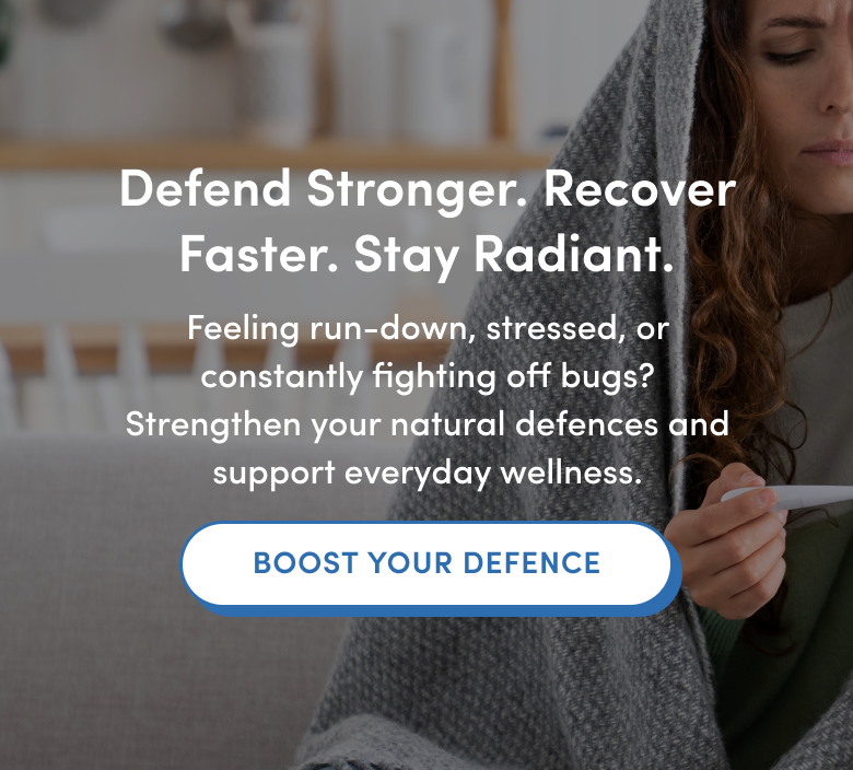 A woman wrapped in a blanket holds a thermometer and sits on a couch. Overlay text promotes boosting natural defences, recovering faster, and supporting wellness, with a button labeled BOOST YOUR DEFENCE.