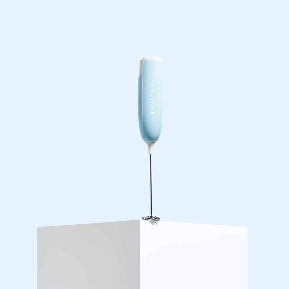 Portable handheld Collagen Mixer in light blue displayed on white pedestal against blue background