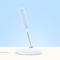 A light blue Collagen Mixer by The Collagen Co USA stands upright on a round white base against a matching light blue background.