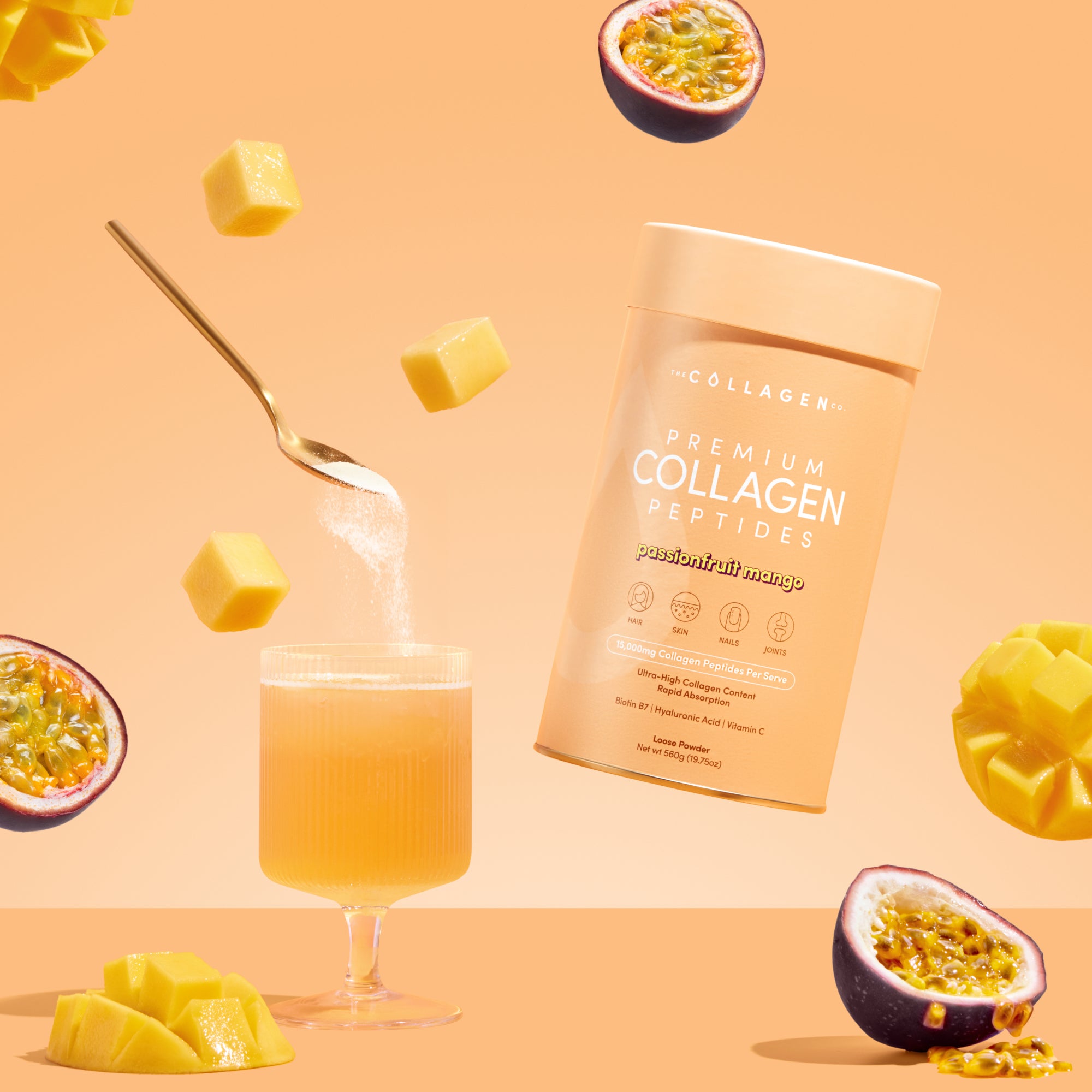 A 560g tub of thecollagen.co’s Passionfruit Mango Collagen Powder is shown next to a glass of orange drink, sugar being poured in, mango cubes, and halved passionfruits on a peach-colored background.