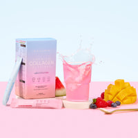 A box of thecollagen.co Mixed Flavors Collagen Sachets (270g), a vibrant pink anti-ageing drink, fresh watermelon, diced mango, berries, and a single sachet are artfully arranged on a pastel pink and blue background.