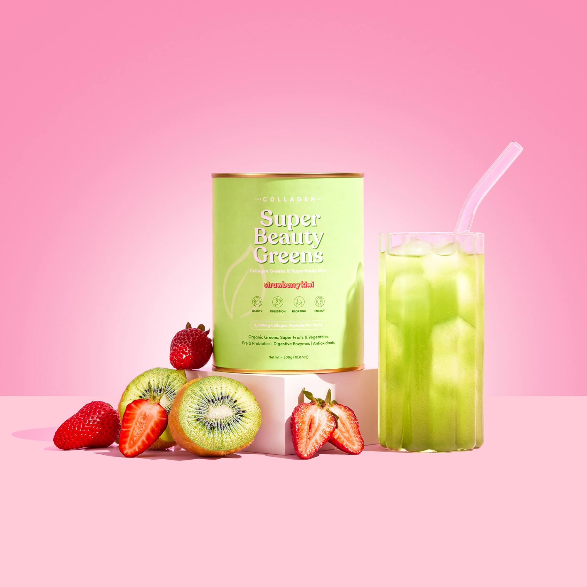 Green collagen supplement container, labeled "Super Beauty Greens," with strawberries, kiwi, and a glass of green juice on a pink background.