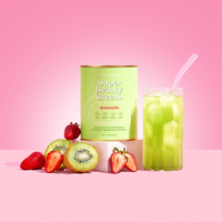A canister of The Collagen Co USA Strawberry Kiwi Super Beauty Greens - 308g, made with organic greens, is shown next to a green drink, fresh strawberries, kiwi slices, and set against a pink background.