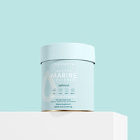 A light blue container of The Collagen Co. Unflavored Beauty Marine Collagen Powder (284g) sits on a white surface against a light blue background, featuring its hydrolysed marine collagen and key ingredient and benefit details on the label.