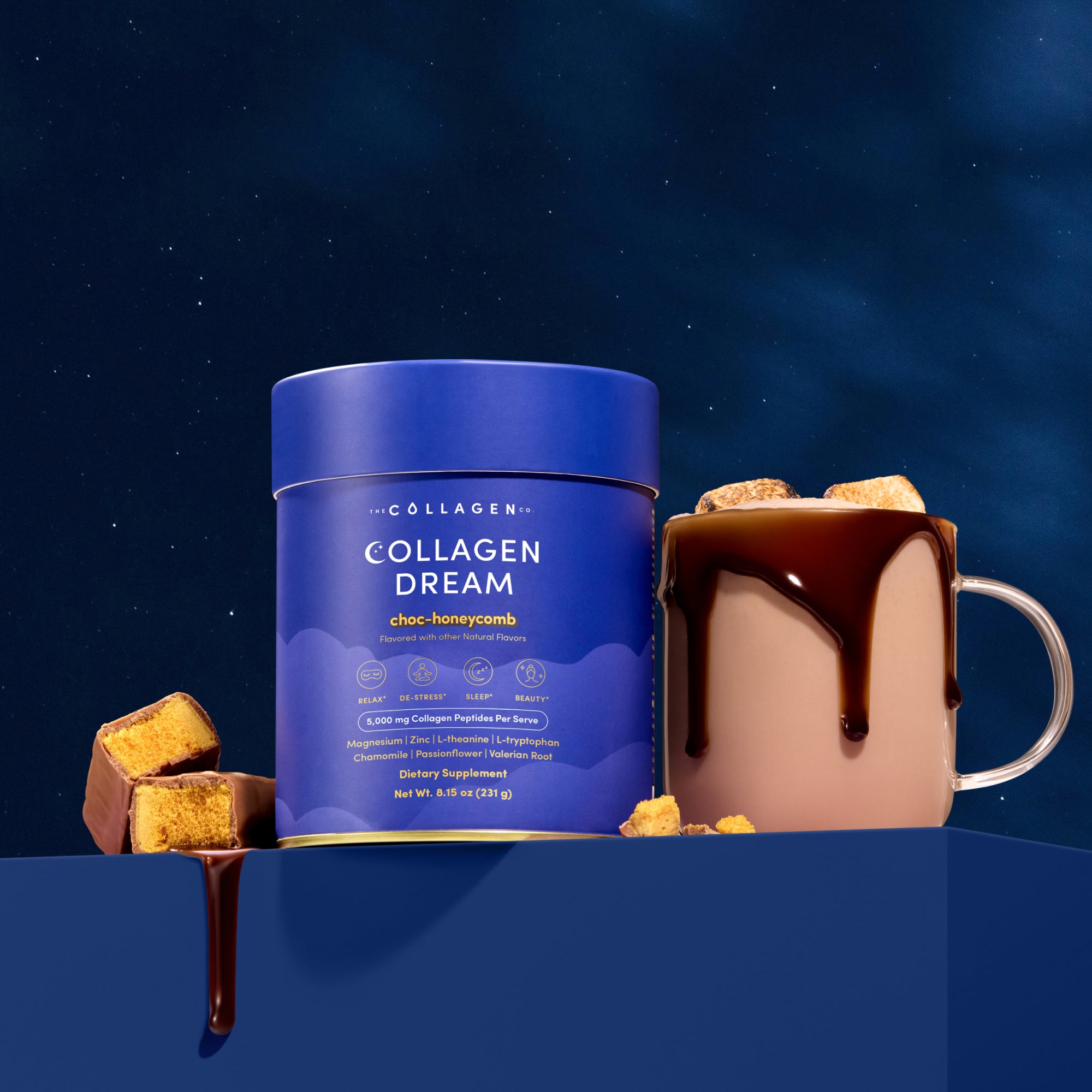 A blue tub of The Collagen Co. Choc-Honeycomb Collagen Dream Advanced Sleep Formula Hot Chocolate (231g) sits next to a collagen-infused hot chocolate mug, chocolate dripping over the rim, with honeycomb pieces and a starry night sky backdrop.