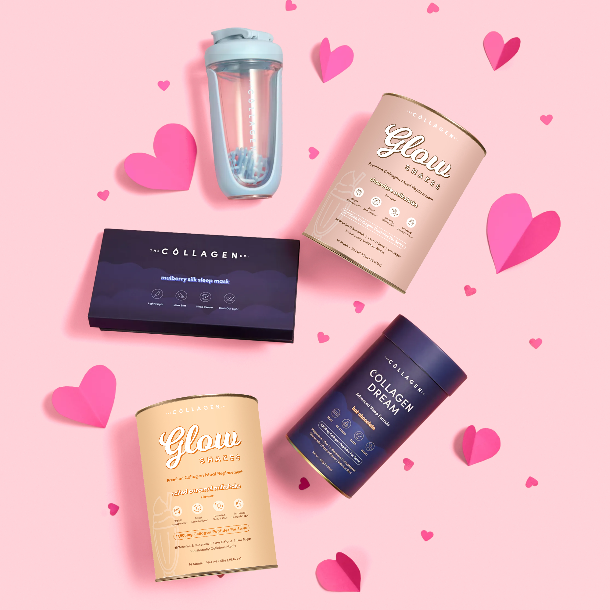 A flat lay of The Collagen Co.'s The Overnight Glow Bundle—featuring tubs, a shaker bottle, a mask box, and pink hearts on pastel pink—perfect for those seeking collagen shakes and wellness support.