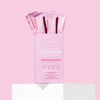 Pink box of collagen peptides with multiple packets on a pink background