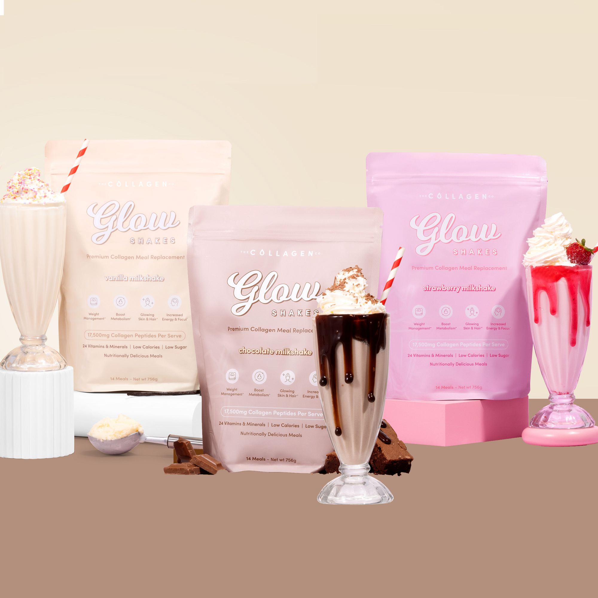 Collagen shake packages in pink and cream with three milkshakes, one chocolate, one vanilla, and one strawberry, decorated with whipped cream.