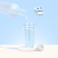 Pouring water into a clear collagen container with a whisk and detachable lid against a pastel blue background.