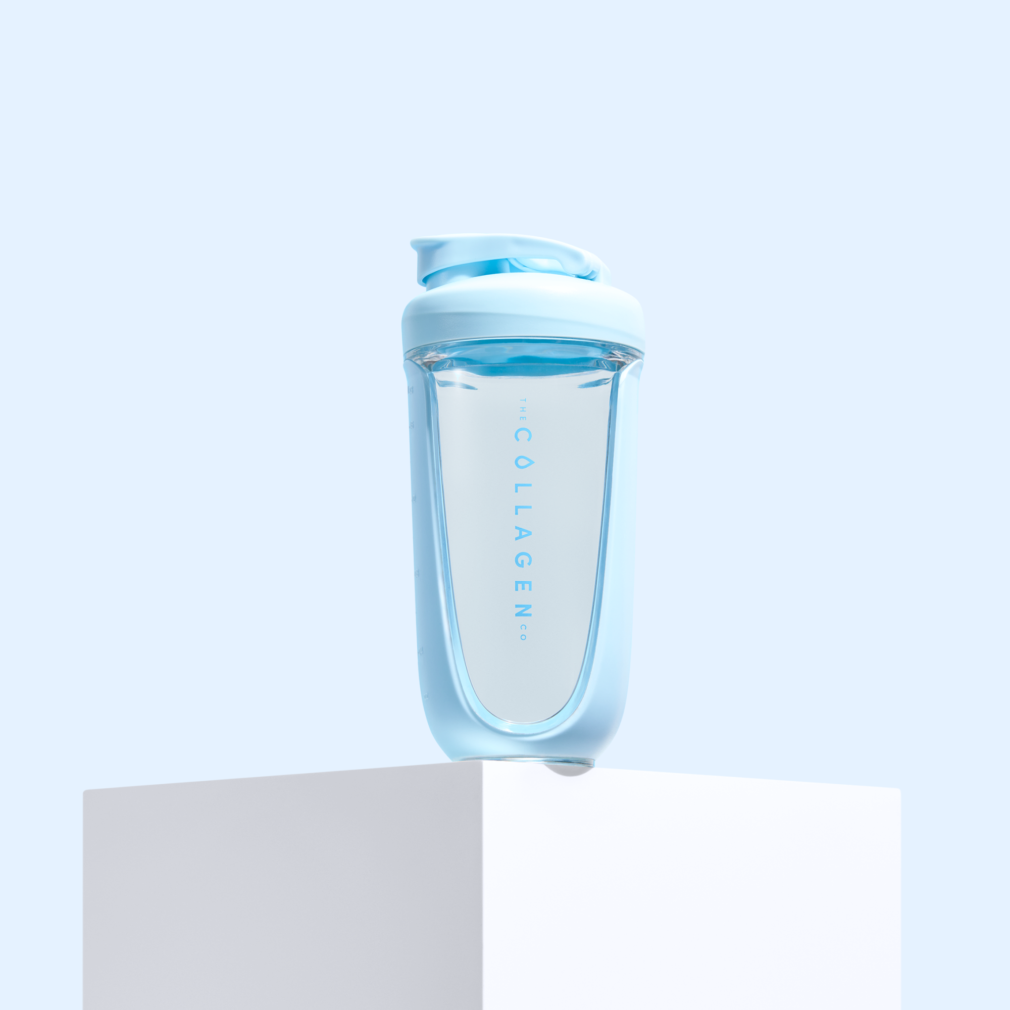 Light blue collagen bottle with a sleek design, sitting atop a white cube against a soft blue background. Ideal for beauty supplements.